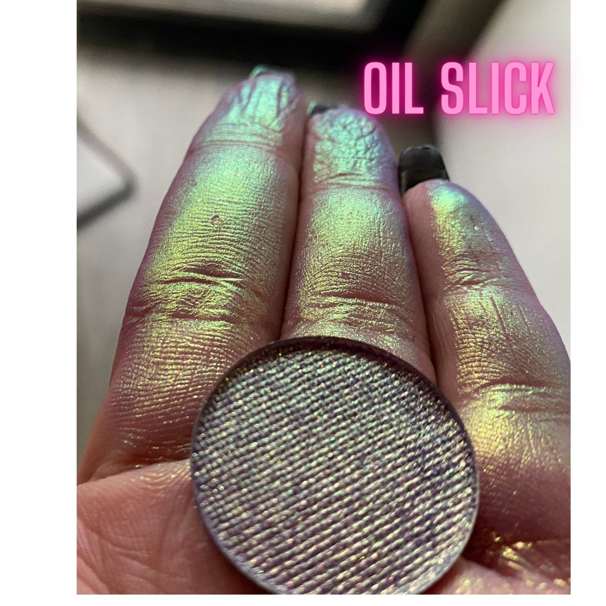 Side view of multichrome eyeshadow palette showing shifting iridescent hues in angled lighting