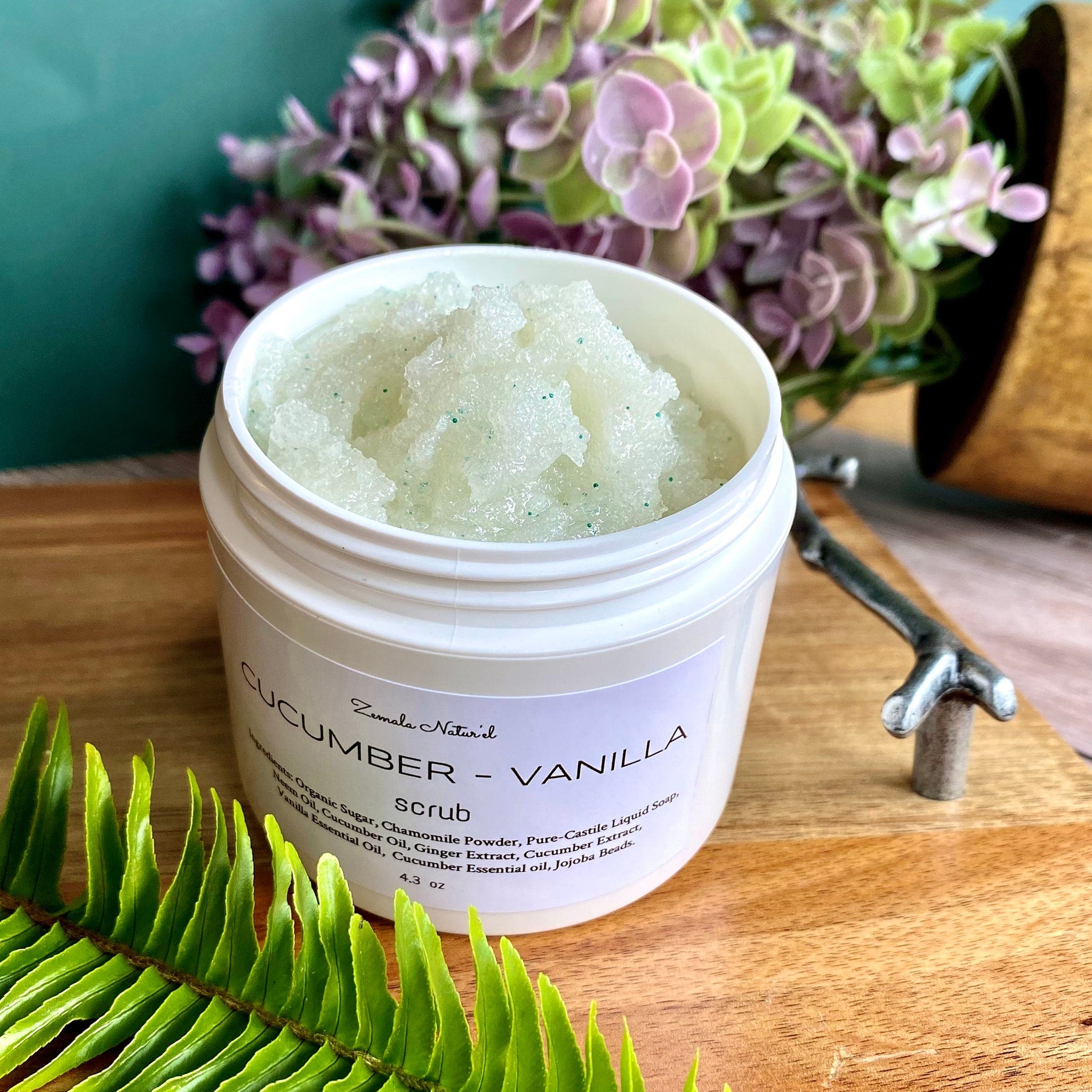 Cucumber Vanilla scrub in white jar with green flecks, Zemala Natur'el label, on wood surface