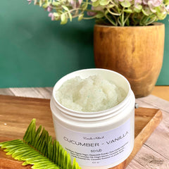 Facial cleanser scrub in white jar with green flecks, Zemala Naturel brand on wooden surface