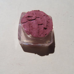 Eye shadow, shimmering mauve powder in clear plastic container, close-up shot