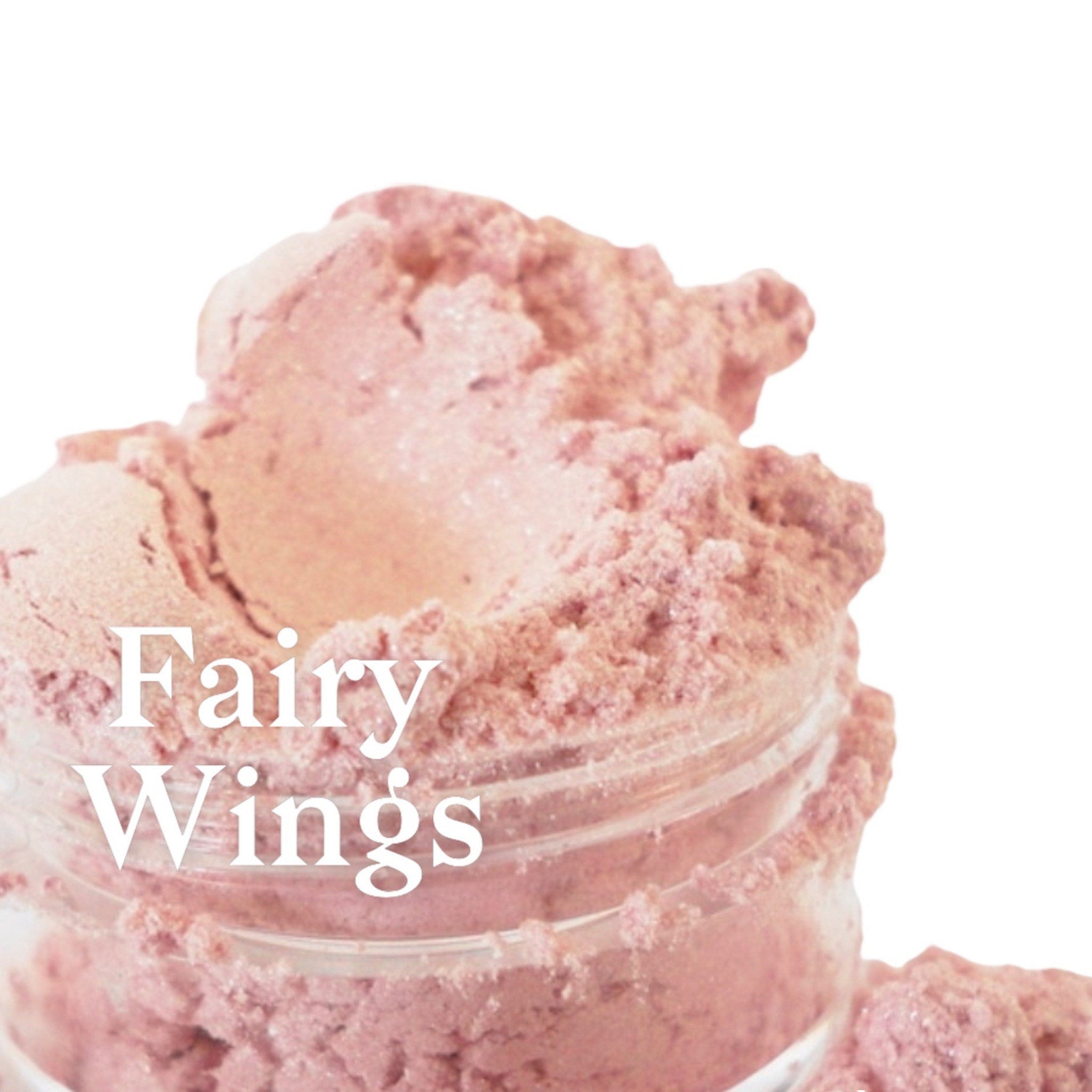 Close-up swatch of iridescent white and pink mineral eye shadow duo showing shimmering color shift on skin