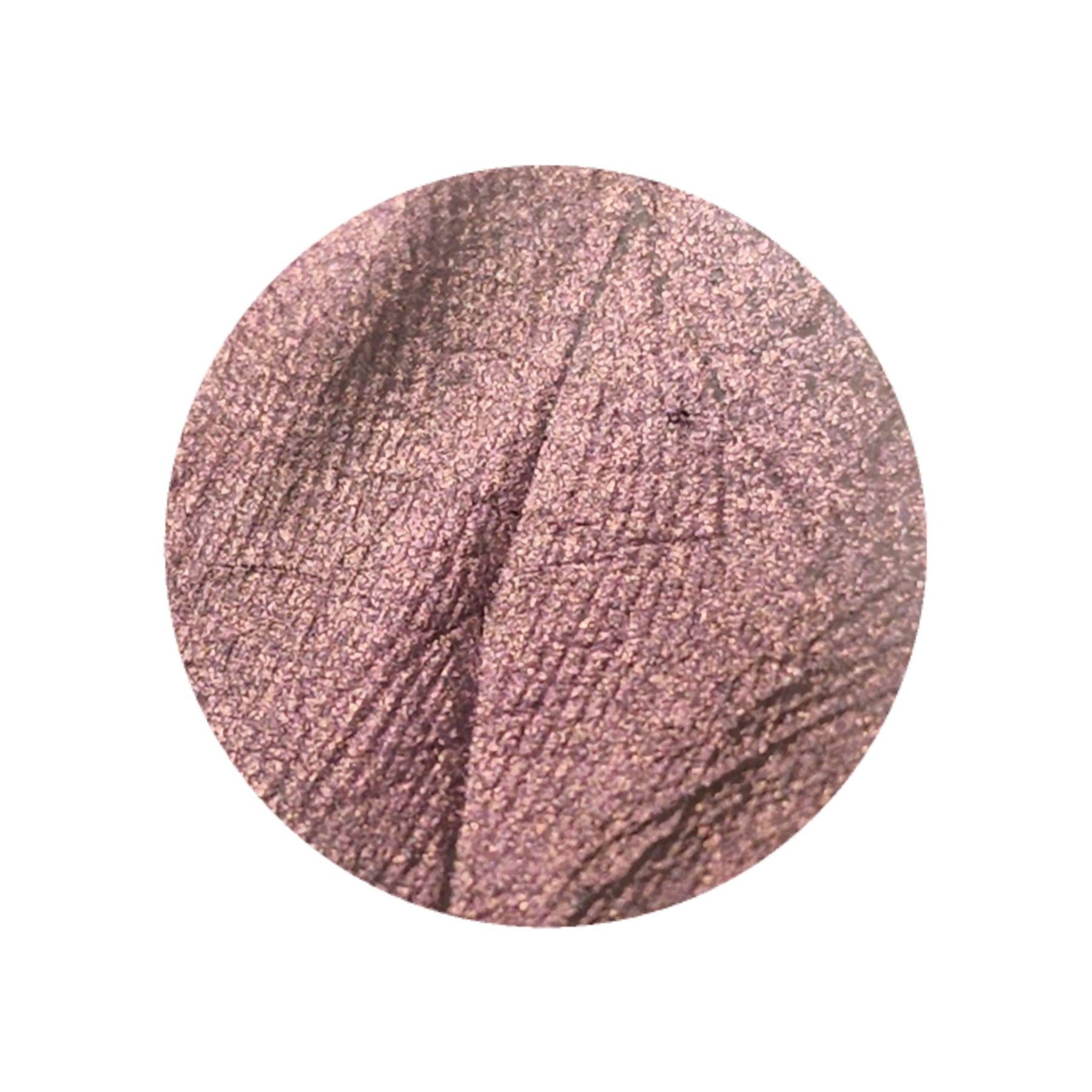 Close-up of vegan multichrome eyeshadow pan shifting from orange to pink with olive undertone shimmer
