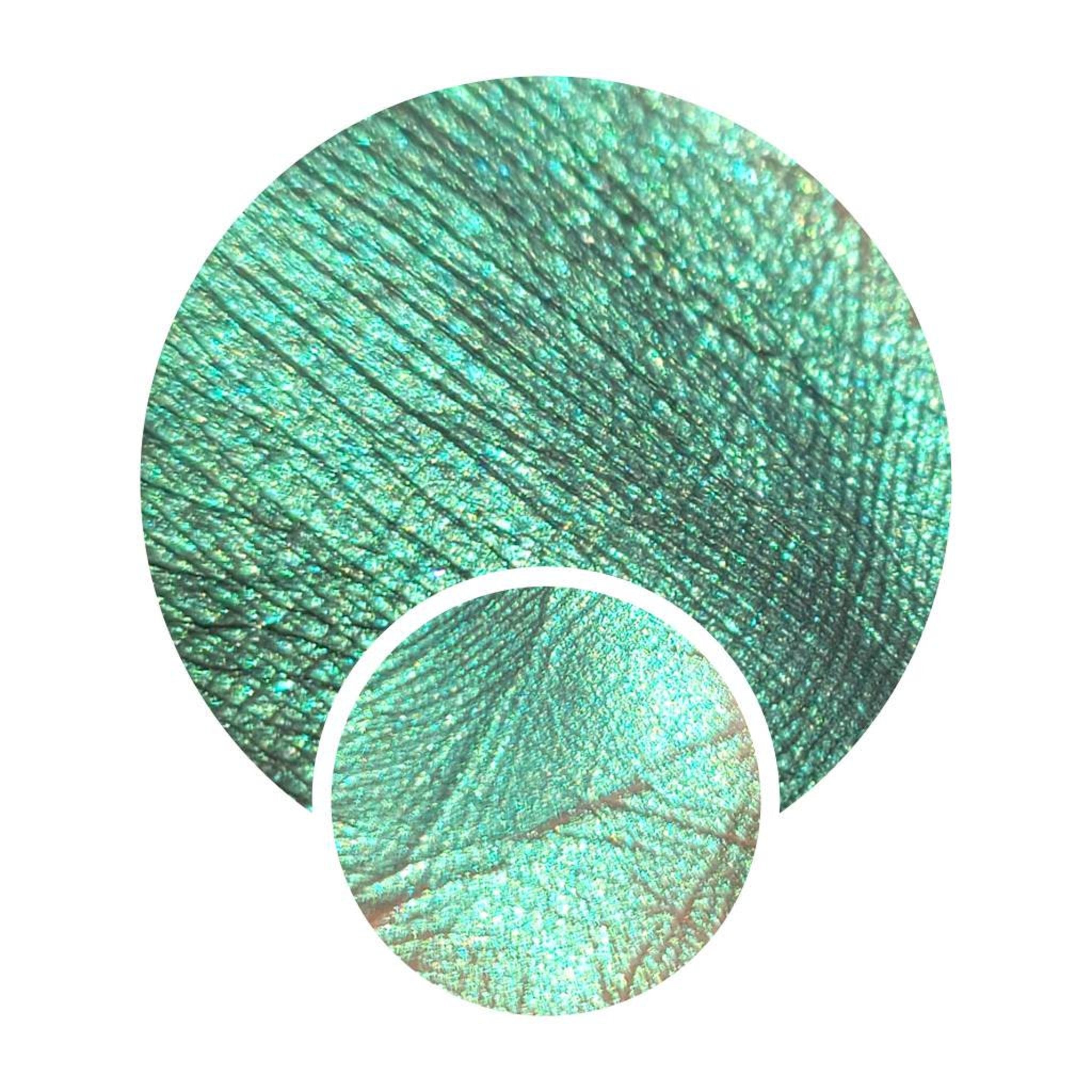 Eyeshadow swatch with emerald green shimmer and metallic texture in two circles
