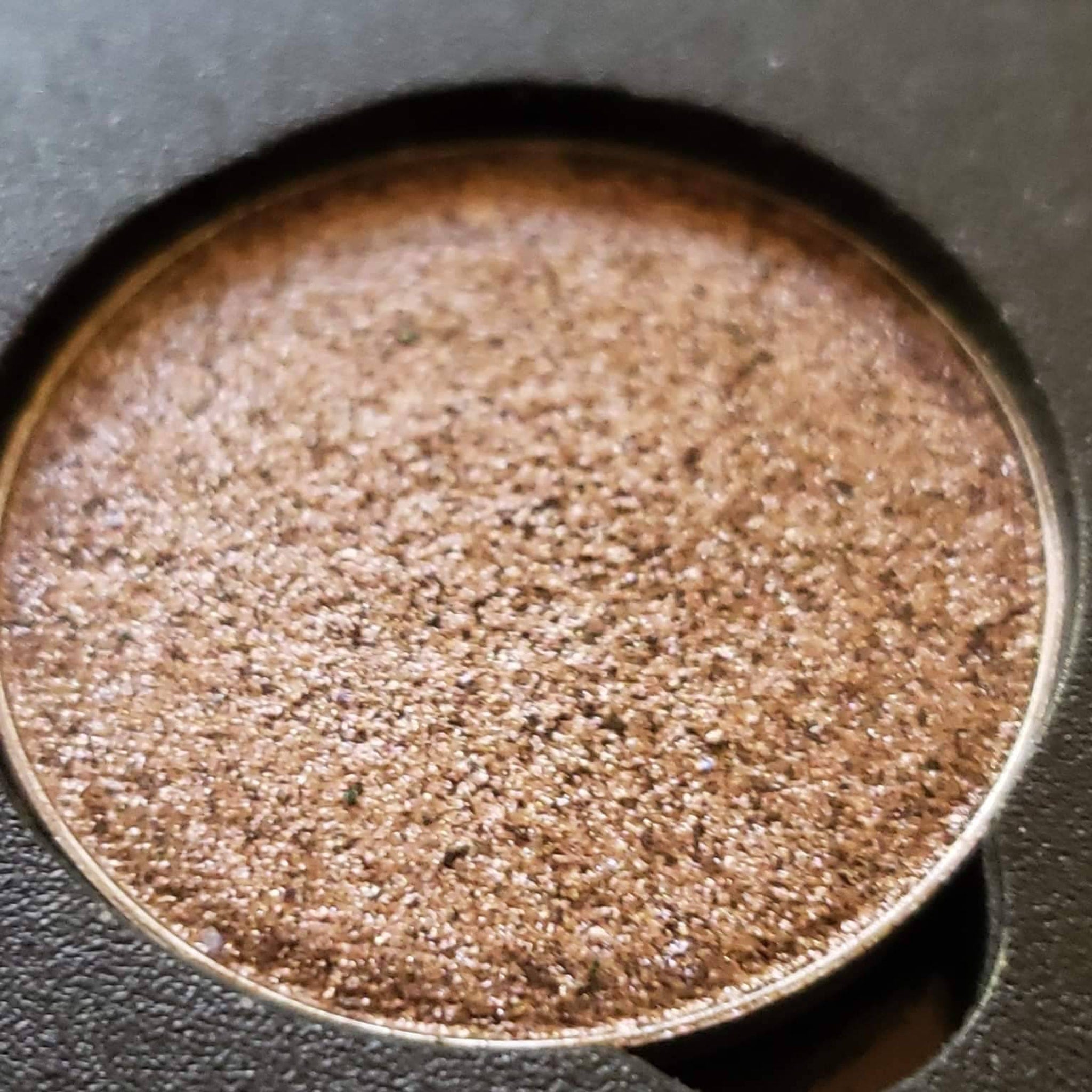 Close-up of Coco Bronze Beige Brown eyeshadow pan showing metallic duochrome shift in warm bronze and cool taupe tones