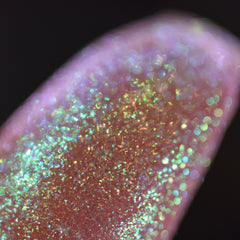 Side view of Moon Dust loose powder eyeshadow showing multichrome shift from silver to pale blue in jar