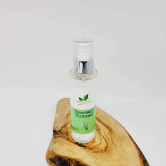 Toner bottle with clear liquid and silver pump, on a wooden surface, JSM Natural Solutions label