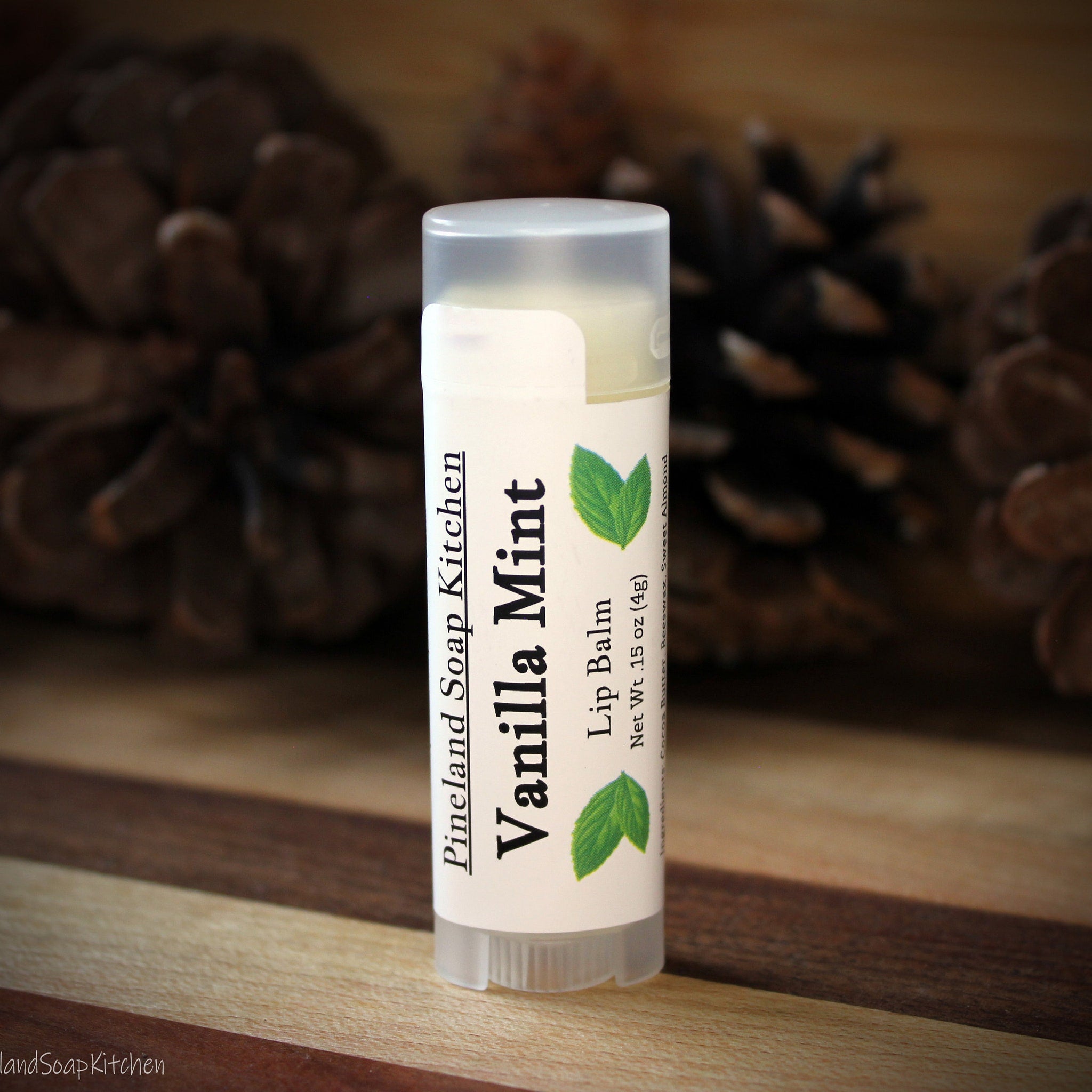 Lip balm tube with white label, clear cap, and green leaf design, Vanilla Mint flavor