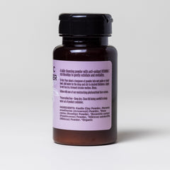 Cleansing powder bottle, brown glass, black lid, purple label with text
