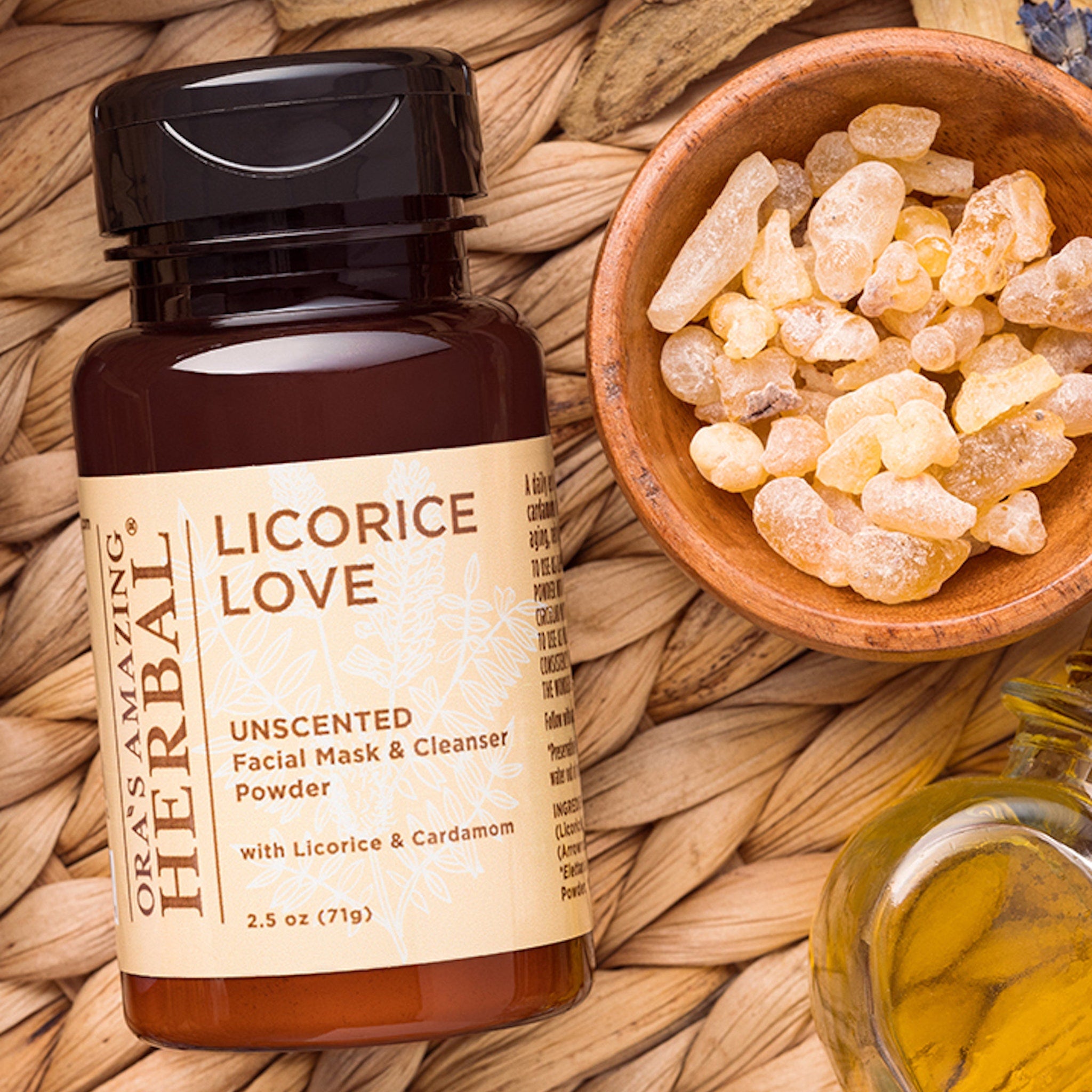 Facial mask powder bottle with brown glass, white label, and wood bowl of crystals on woven mat