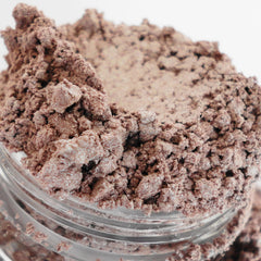Eyeshadow makeup in taupe-pink color with shimmer, in a clear jar with product visible