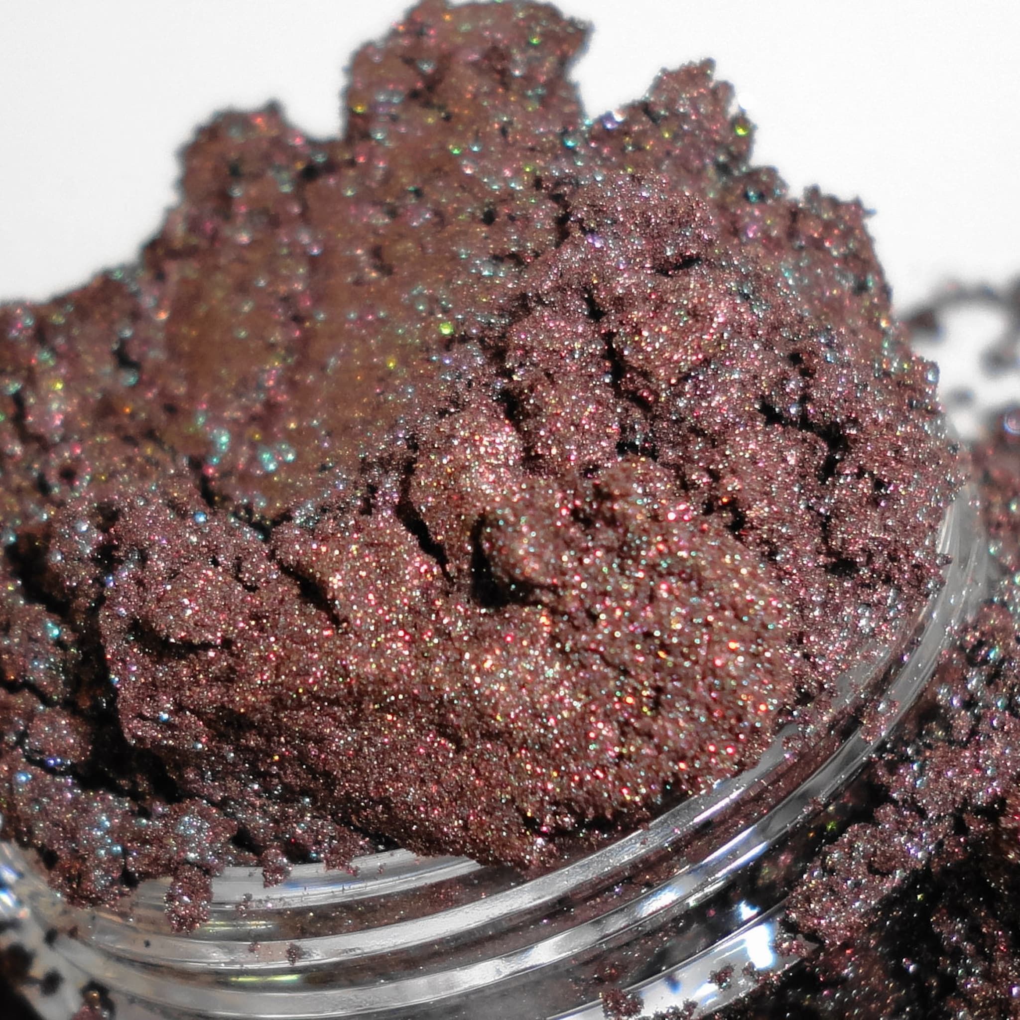 Glitter eyeshadow powder in brown with iridescent shimmer, in a clear jar
