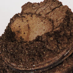 Side view of whiskey copper gold metallic eyeshadow in sifter jar, showcasing shimmer texture and mineral makeup