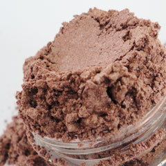 Close-up of whiskey copper gold metallic eyeshadow with shimmer particles in a sifter jar