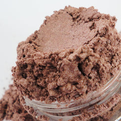 Eyeshadow powder, brown, shimmery, in a clear jar, close up view