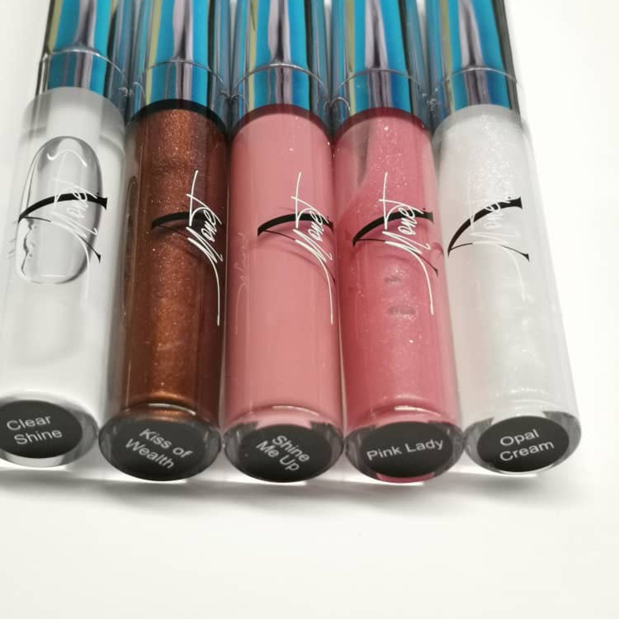 Lip gloss tubes with clear, brown, pink, and white gloss, with "Mone" branding visible on the tubes.