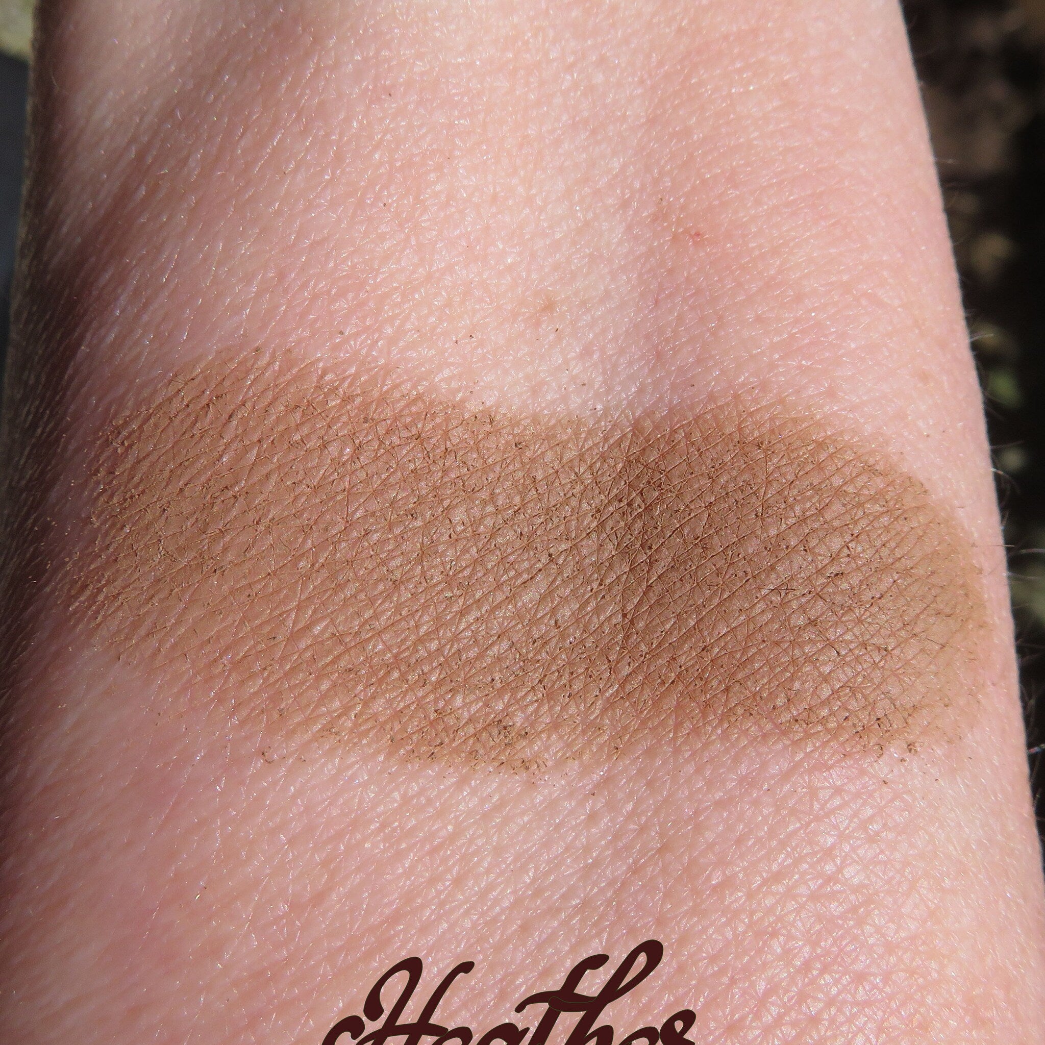 Side view of loose mineral eyeshadow in matte brown shade with eco-friendly packaging and sifter top
