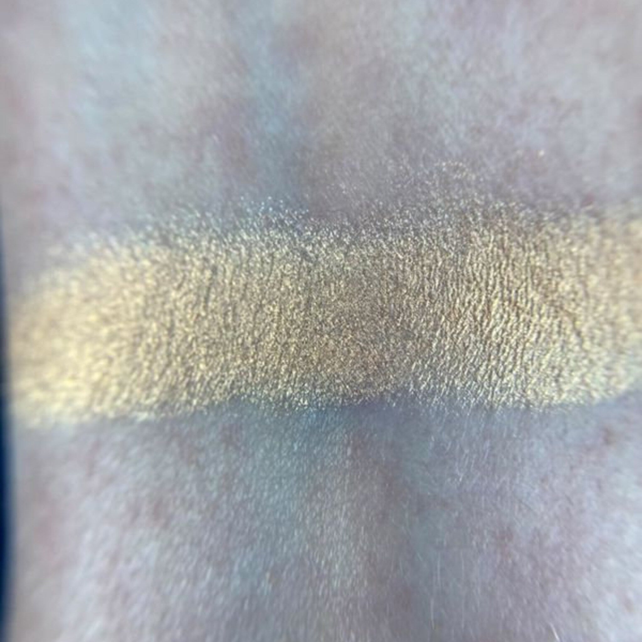 Close-up of May Eyeshadow palette showing shimmering bronze and taupe shades with smooth, blendable texture