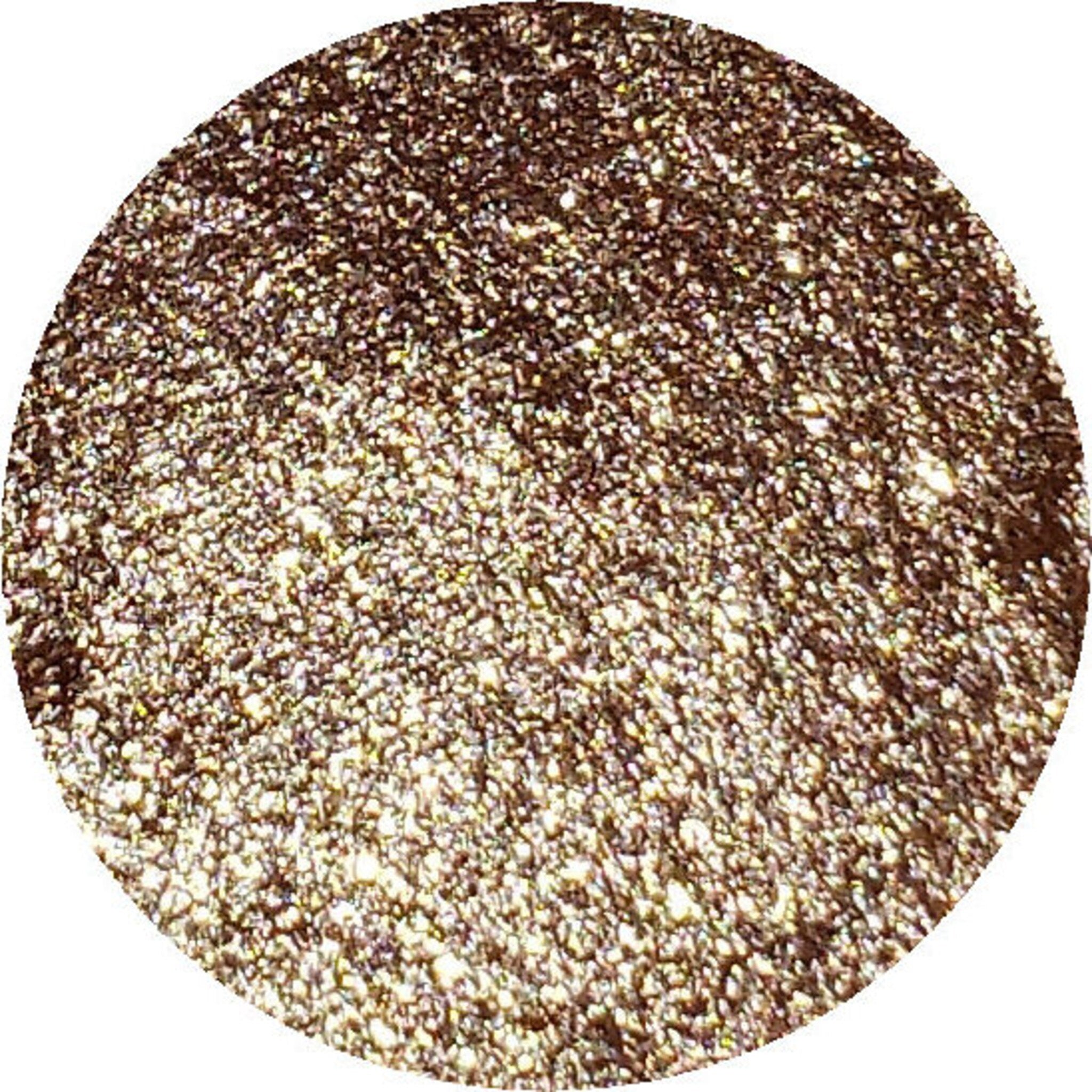 Close-up of shimmering bronze and plum eye shadows in circular pans with embossed moon motifs