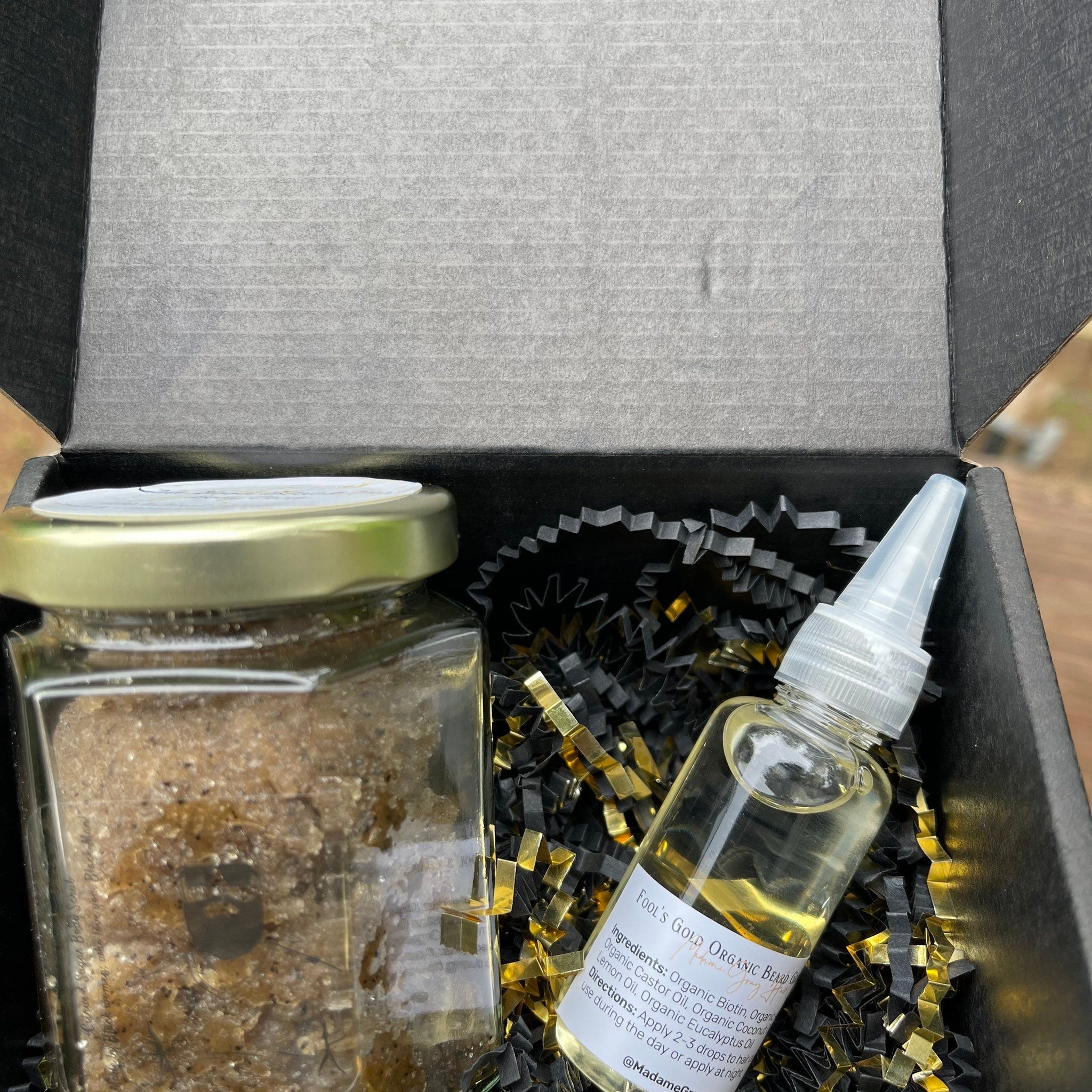 Beard oil and scrub gift set in black box with gold accents and Madame Gray text