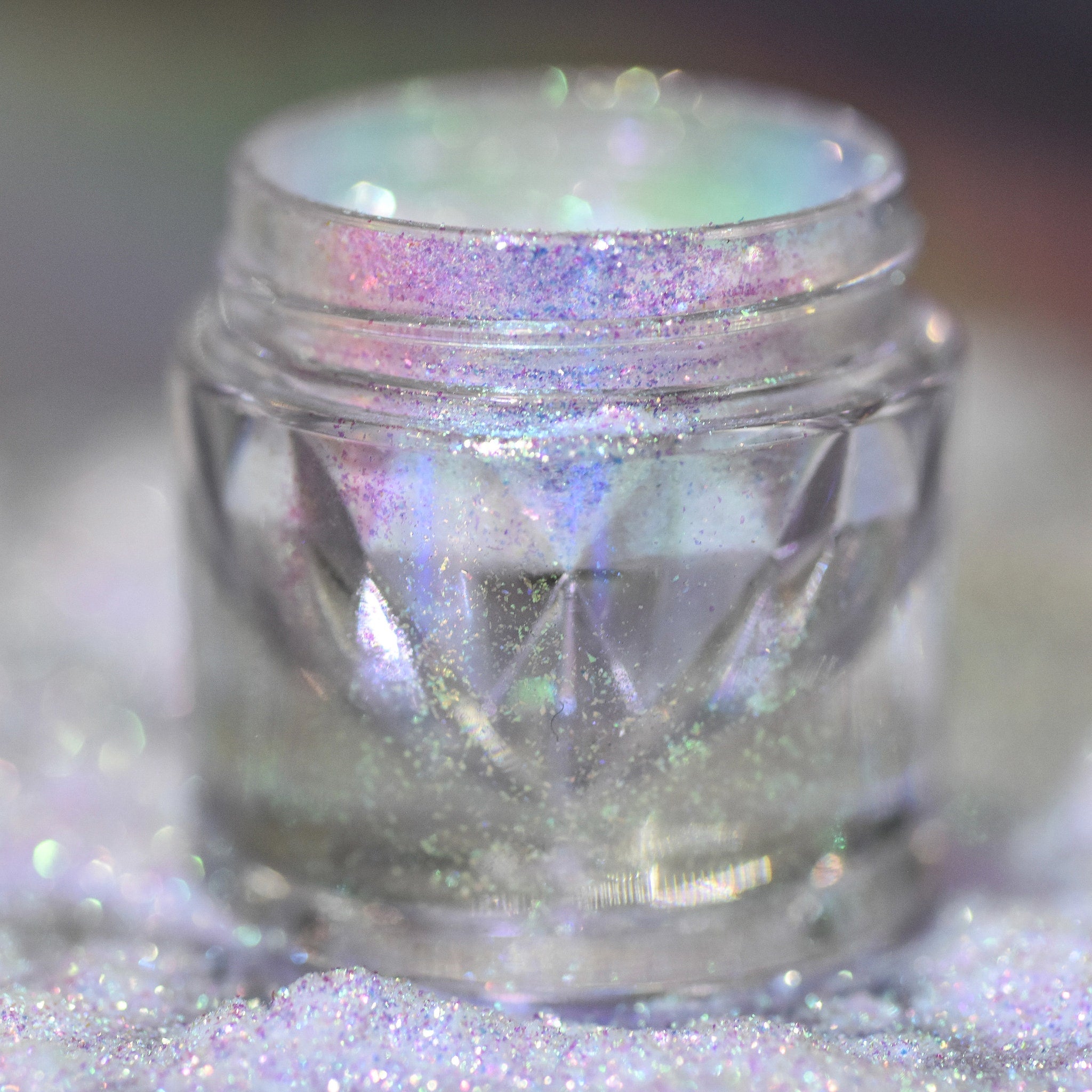 Hand applying shimmering silver-blue loose powder eyeshadow with fingertip for a bold metallic look