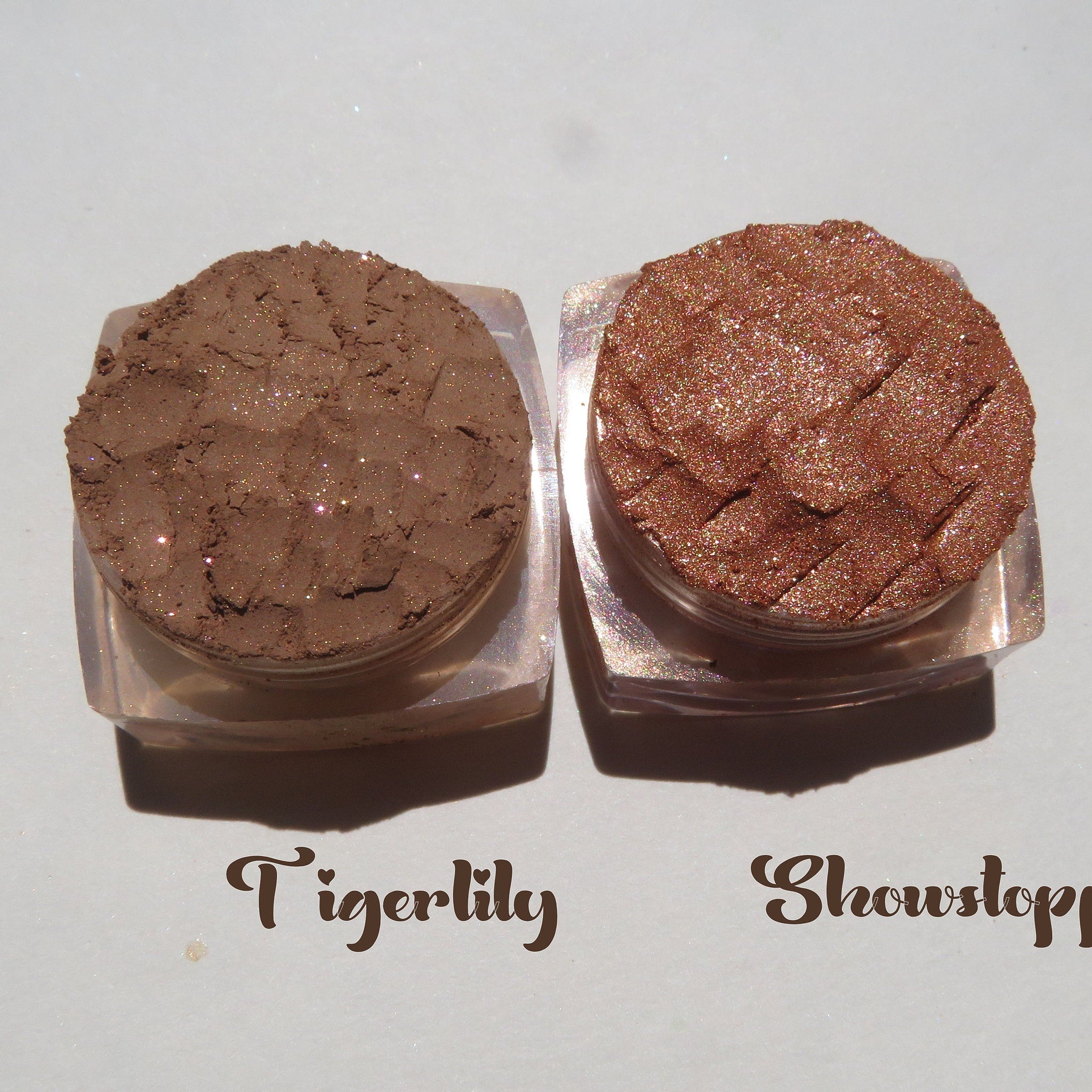 Three circular pans of mineral eyeshadow in autumn brown shades with shimmer, displayed at an angled perspective