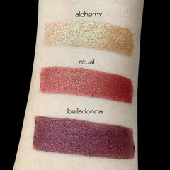 Close-up of loose gold vegan mineral eyeshadow with shimmering metallic finish in a sifter jar