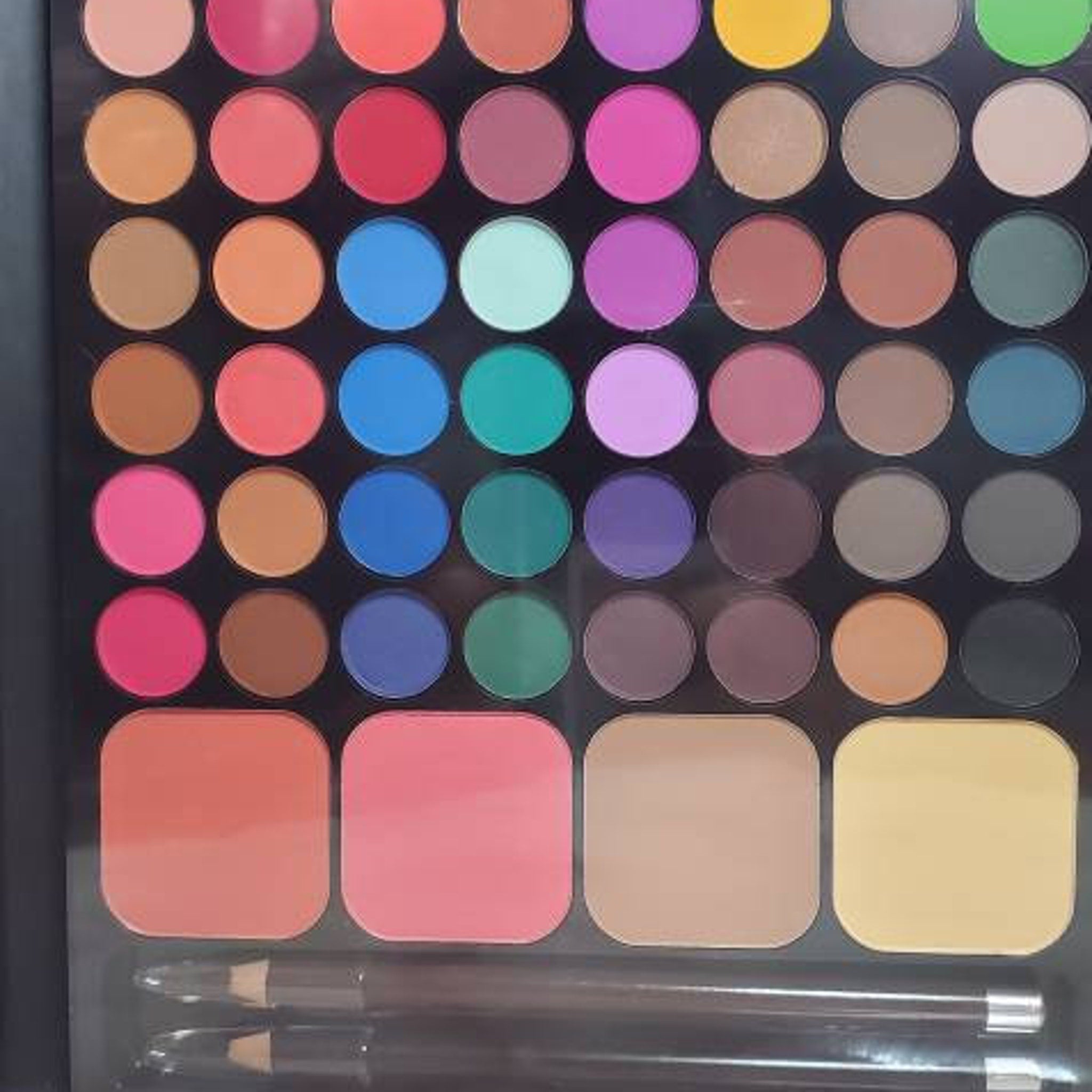Eyeshadow palette with multiple colors, round pans, and blush with pencils at the bottom.