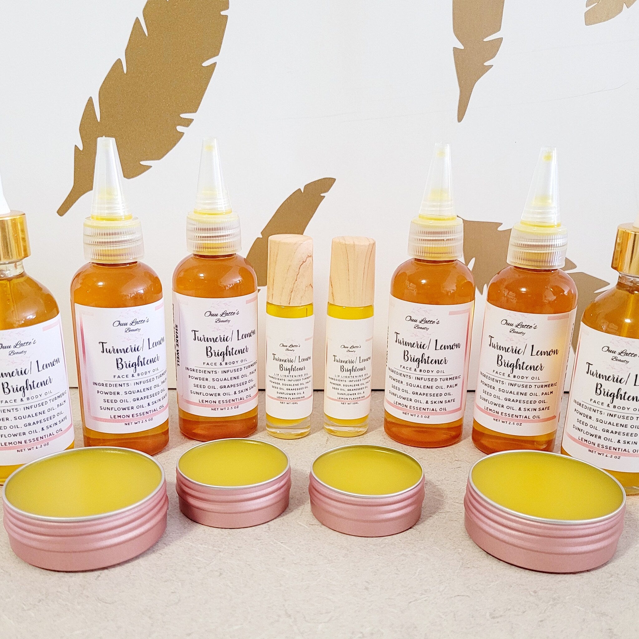 Turmeric Lemon Brightener bottles, amber liquid, clear spray tops, and pink lip balm tins