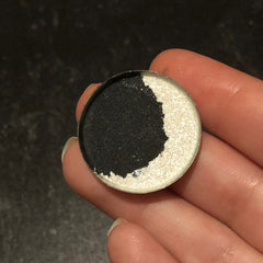 Single eyeshadow in waxing crescent moon shape with shimmering silver-blue hue and smooth satin finish