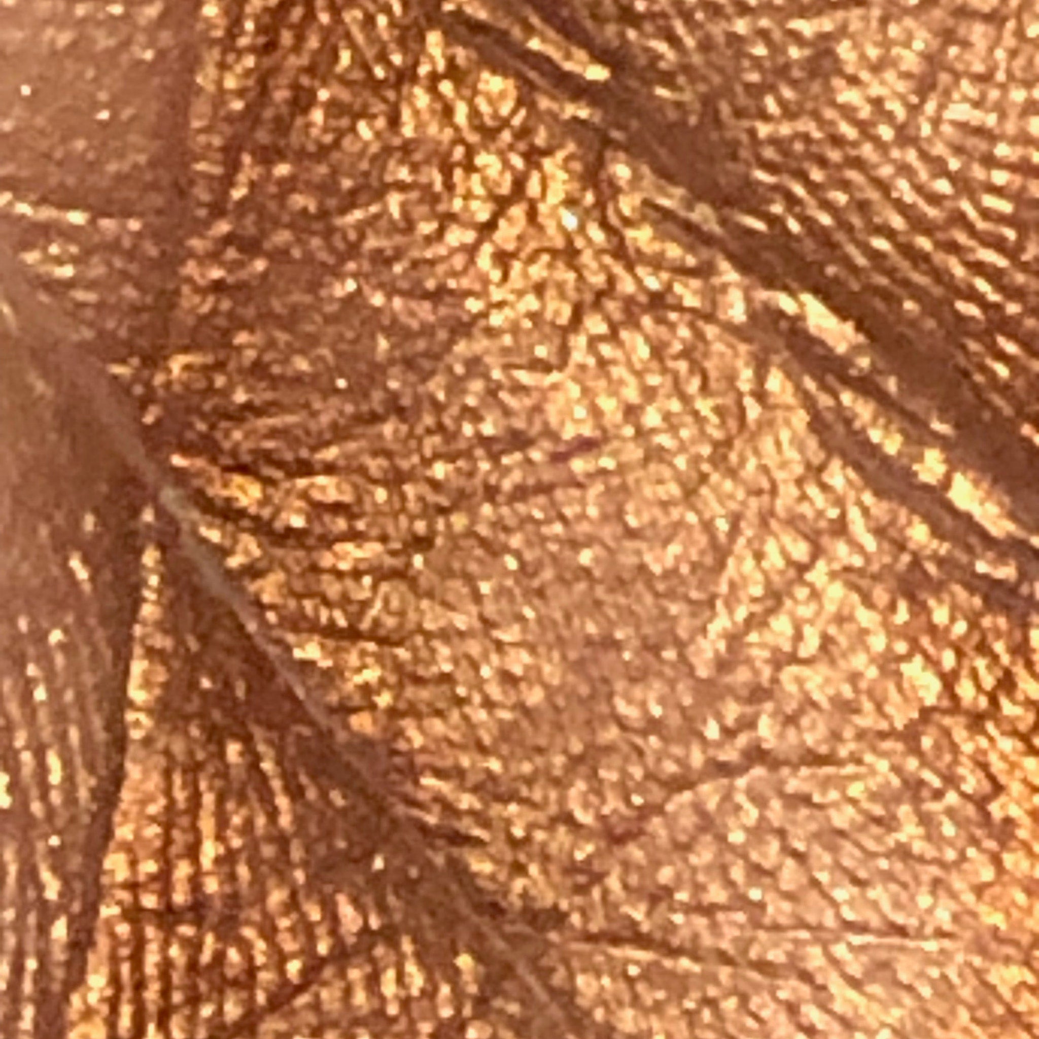 Textured copper material with a subtle pattern and highlights.