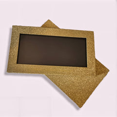 Hand applying golden glitter eyeshadow from magnetic palette with fingertip, showcasing multichrome shimmer effect
