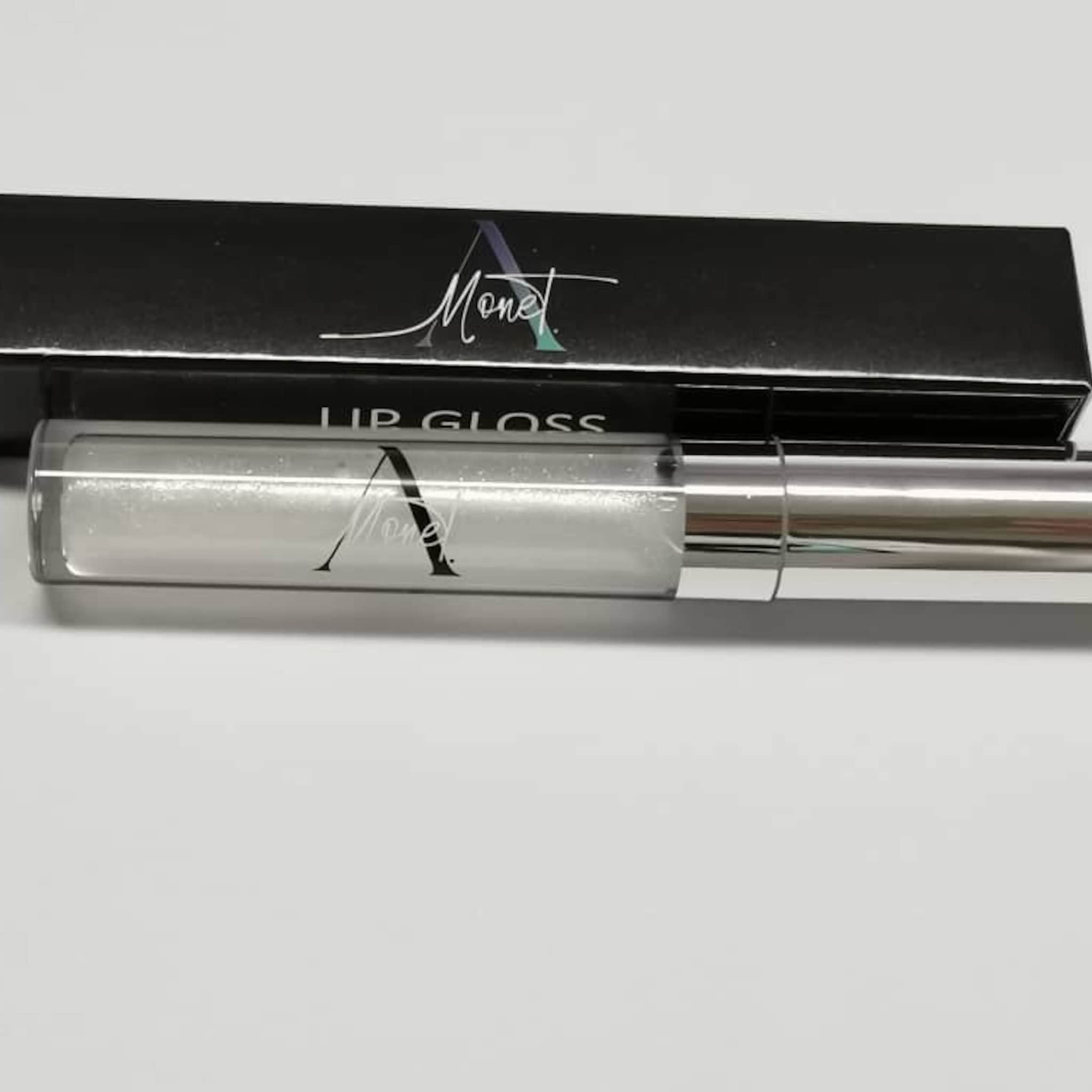 Lip gloss tube with silver metallic cap and clear tube, Monet brand visible on tube and box
