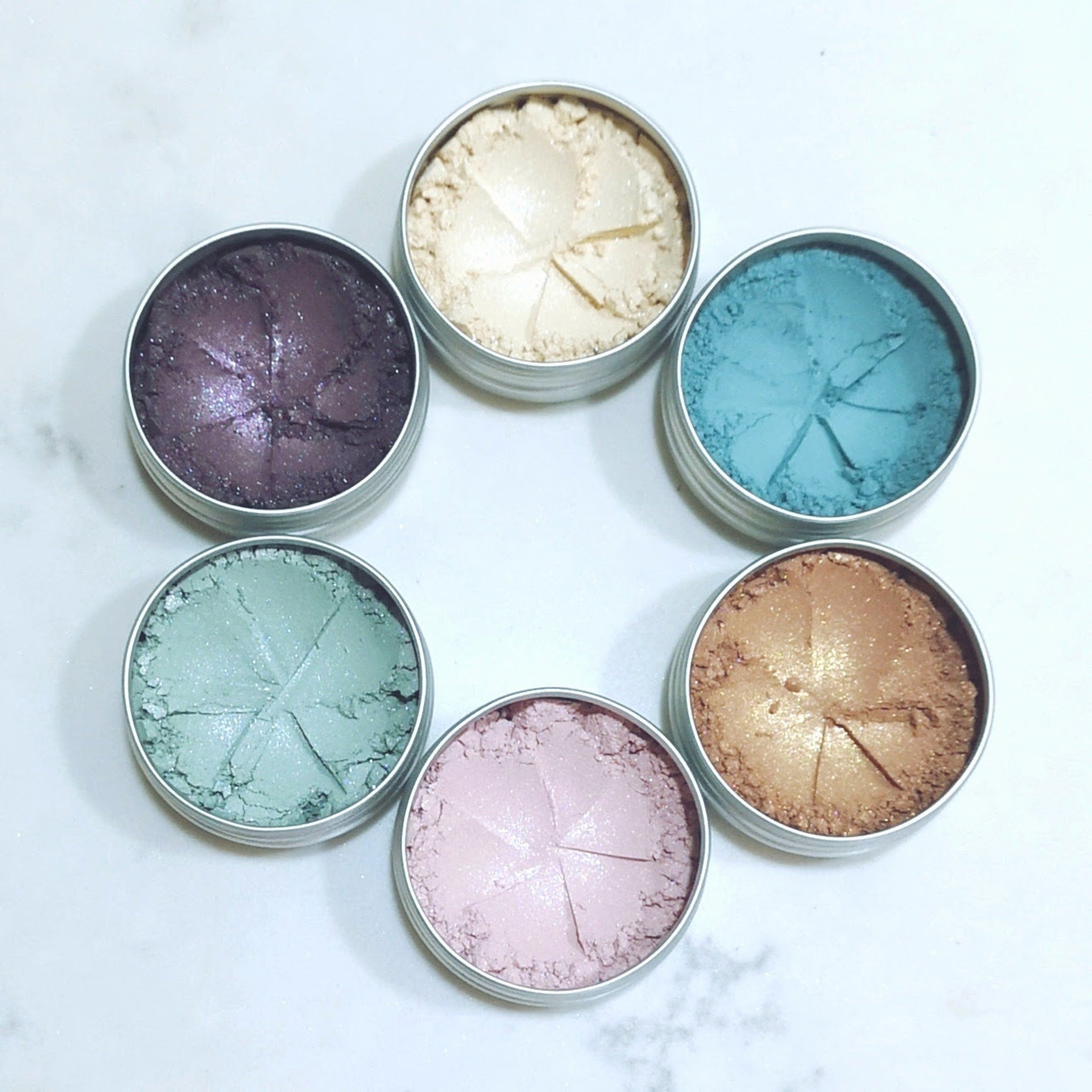 Eyeshadow palette with various colors, metallic finish, and round metal containers