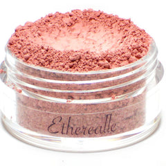 Side view of matte light pink vegan mineral eyeshadow in compact with rounded edges and subtle brand engraving