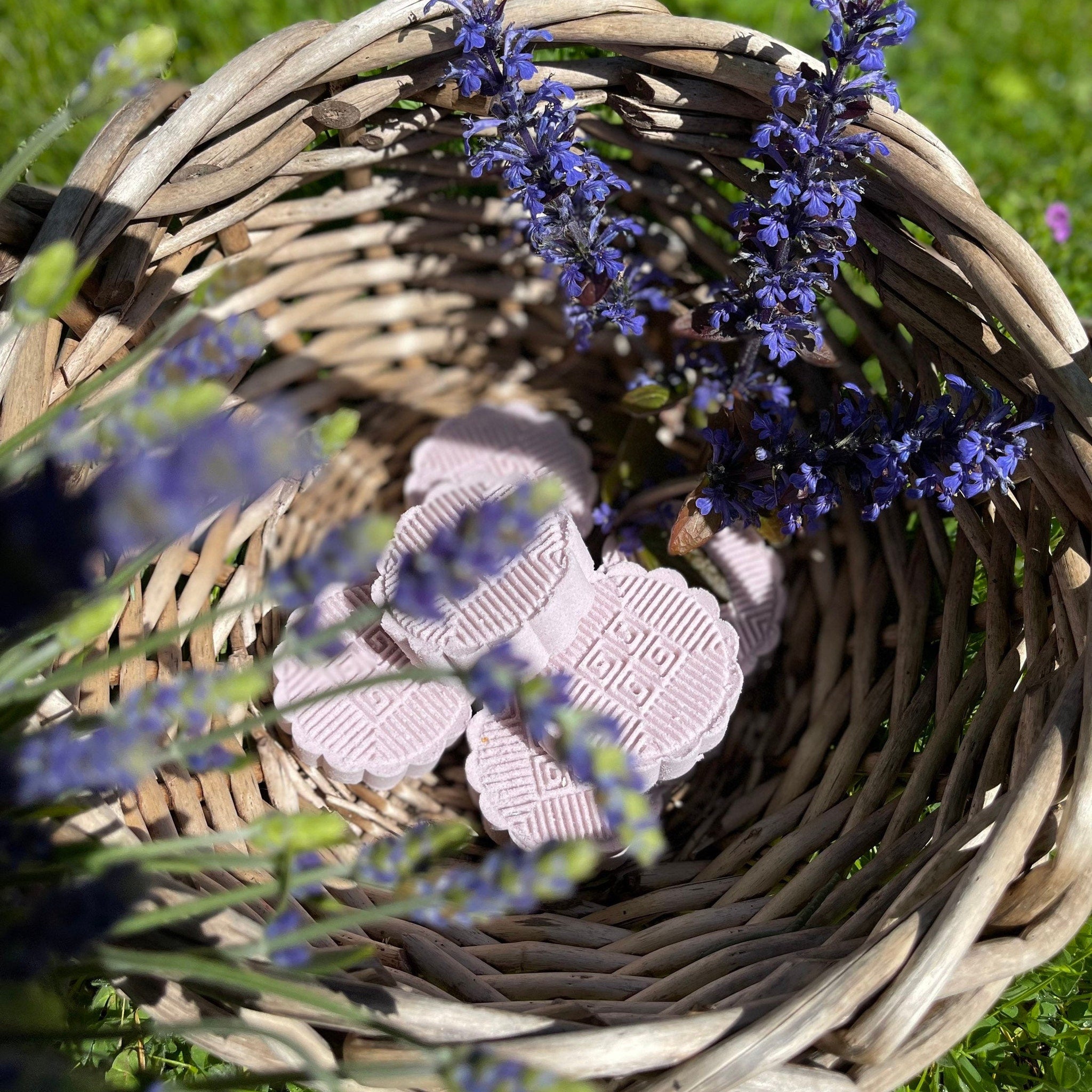 Shower bombs with floral pattern, light purple color, in a woven basket with lavender