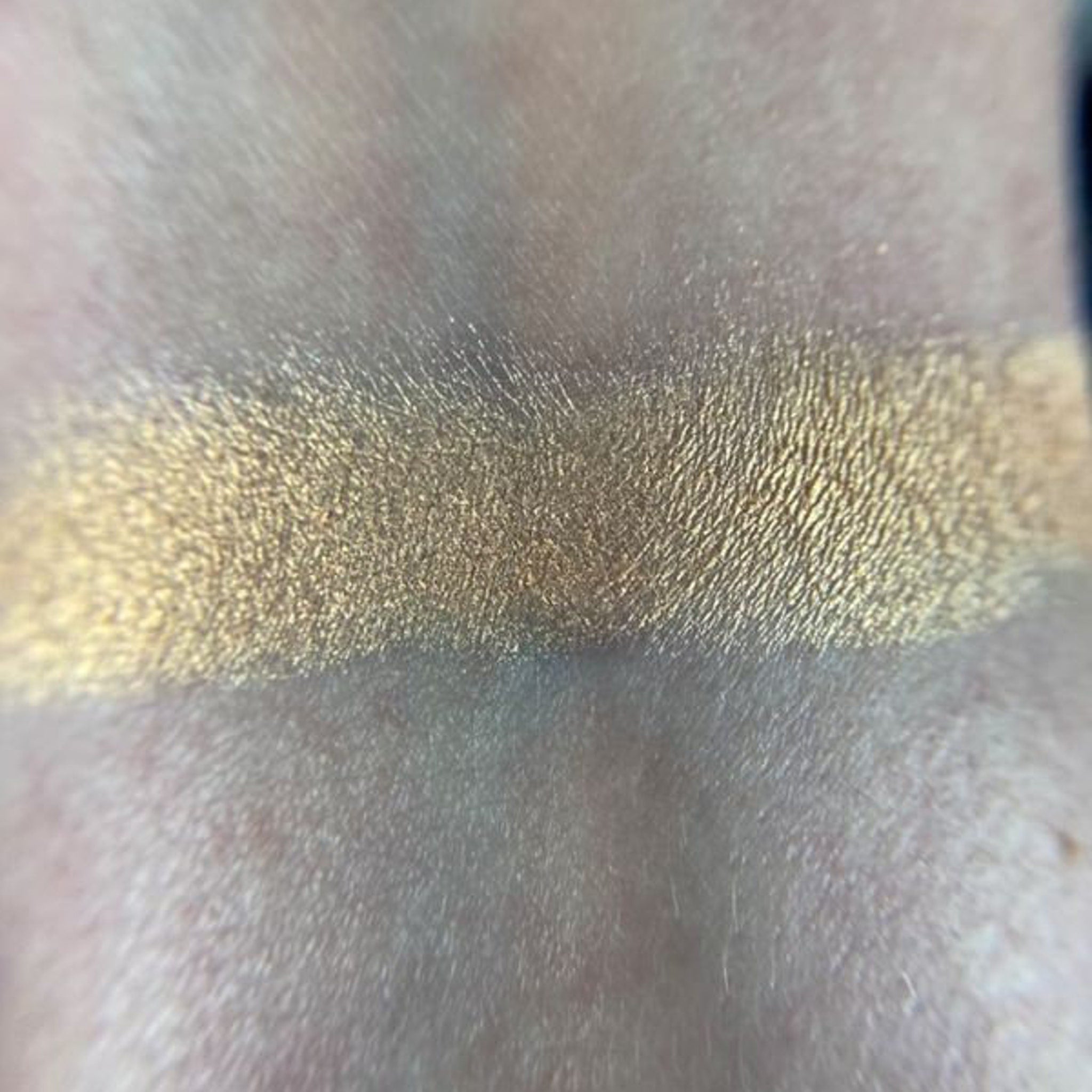Side view of May Eyeshadow palette showing gradient of shimmering bronze to copper shades in rectangular compact
