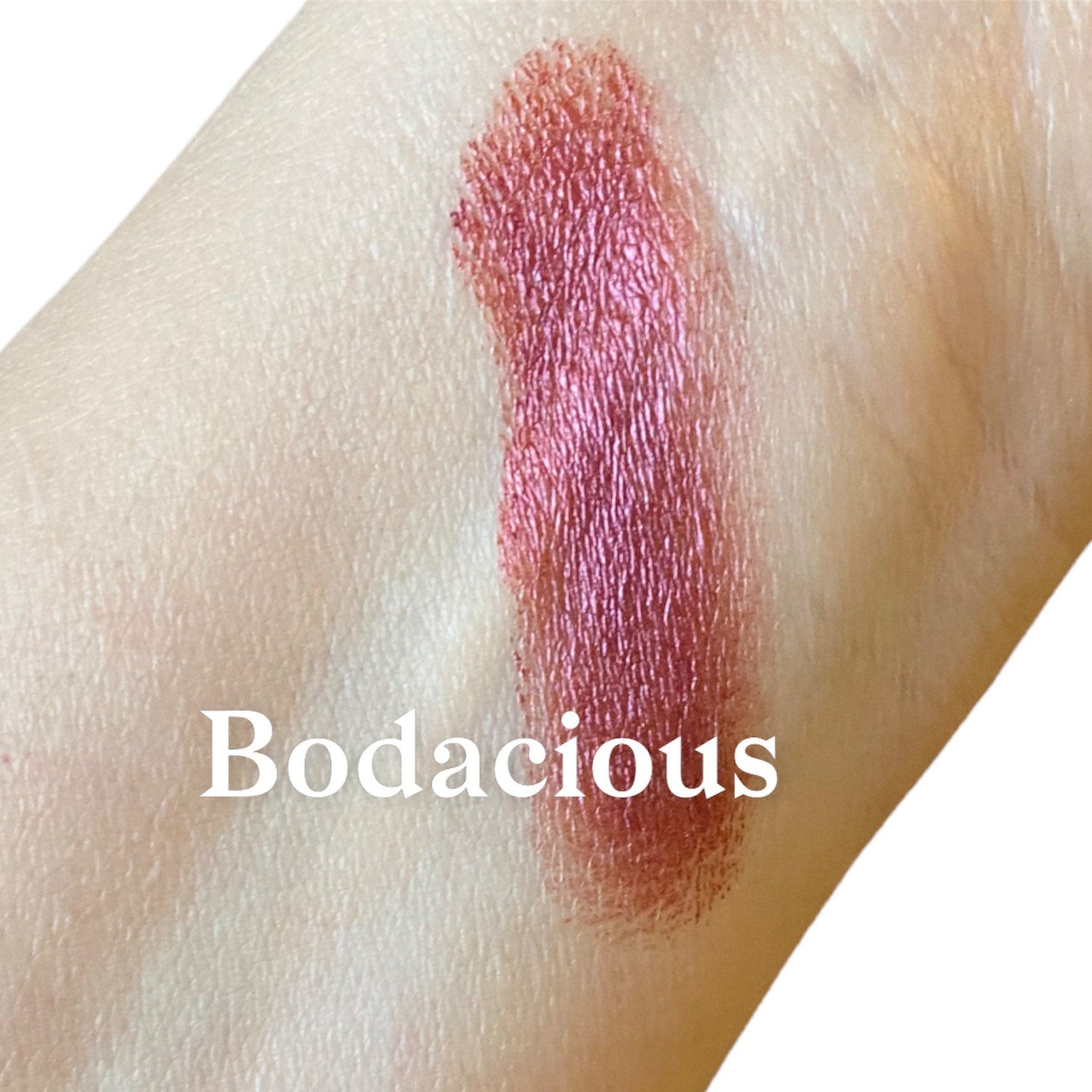 Close-up of burgundy red raspberry mineral eyeshadow with luster finish in sifter jar