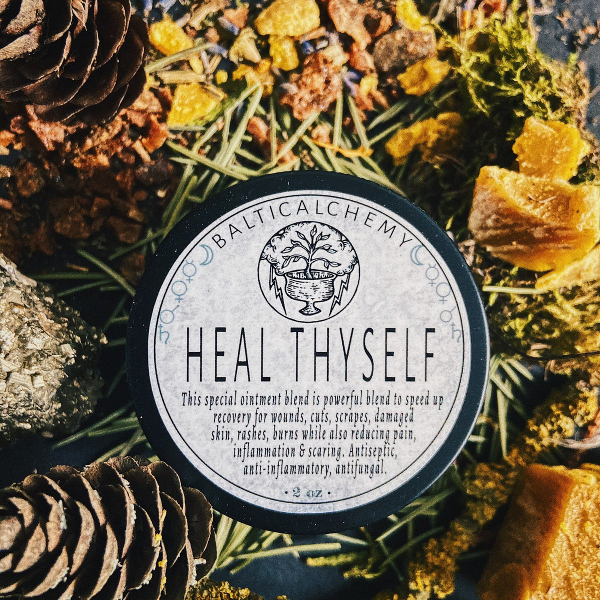 White plastic jar of healing balm with gold lid and minimalist label, 2oz size