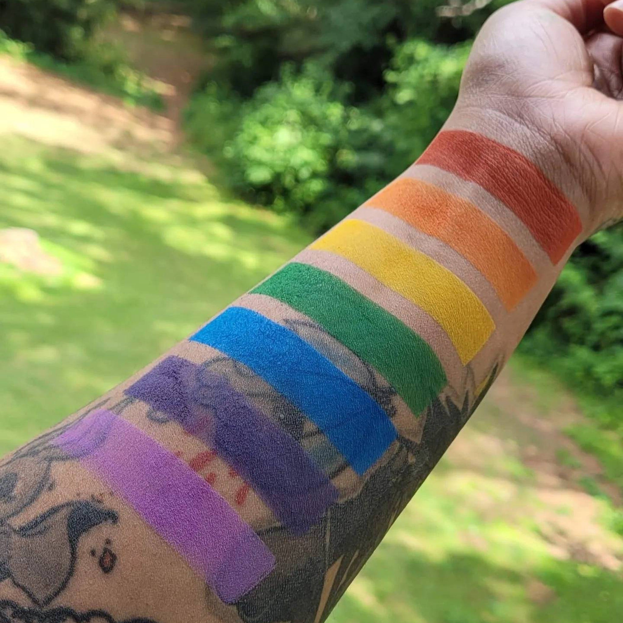 Close-up of matte rainbow eyeshadow palette showing vibrant red, orange, and yellow color swatches