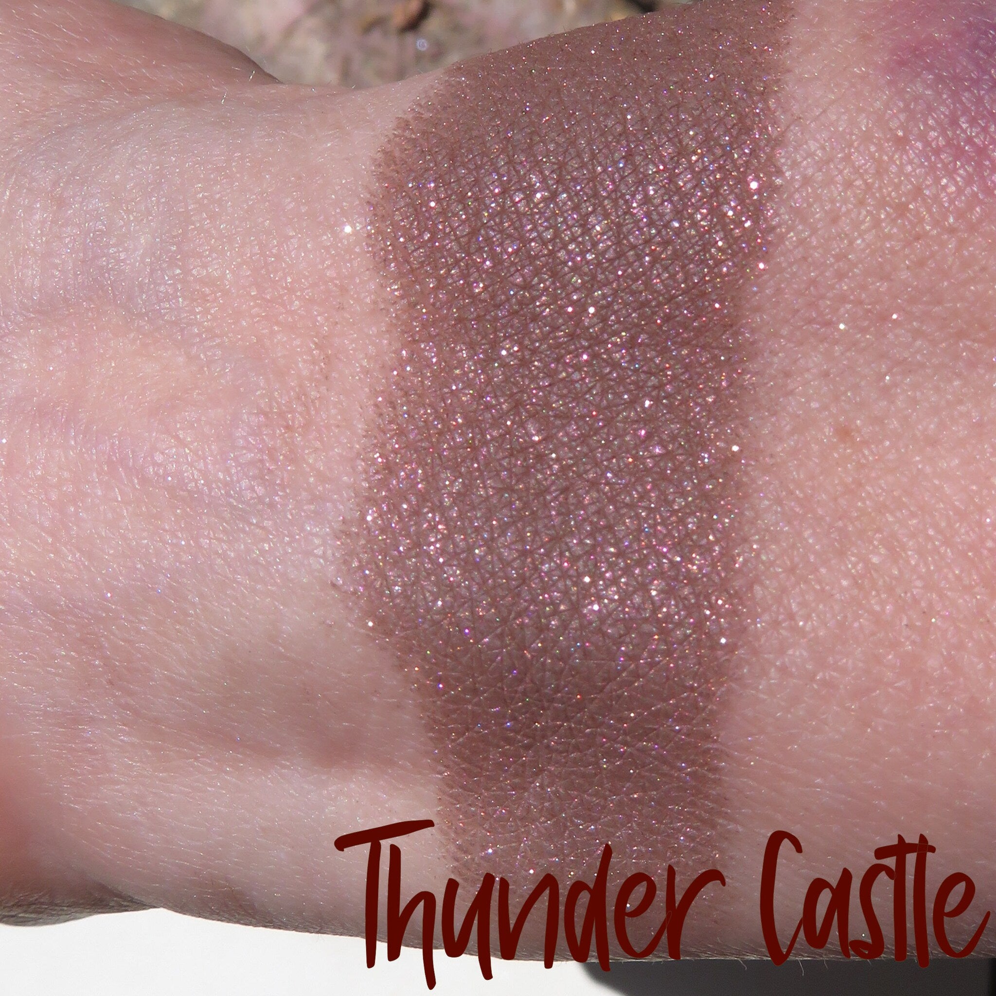 Side view of dark brown shimmer mineral loose eye shadow in eco-friendly packaging with metallic finish