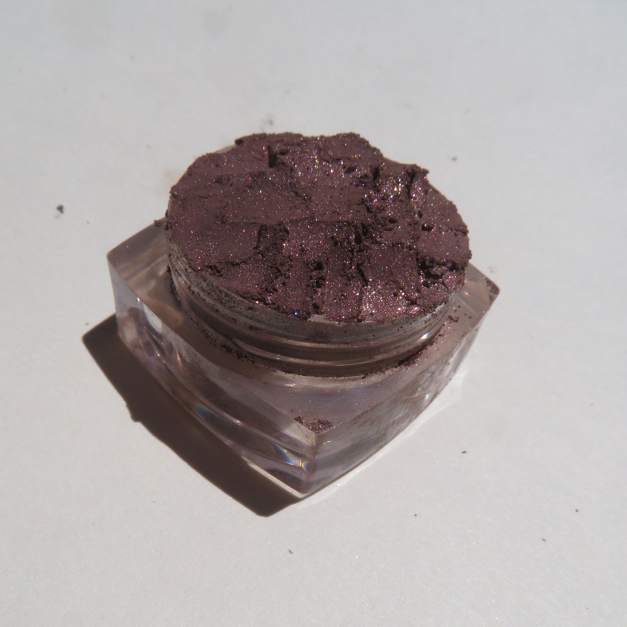 Dark brown shimmer loose mineral eyeshadow in a sleek glass jar with black screw-top lid and Thunder Castle logo.