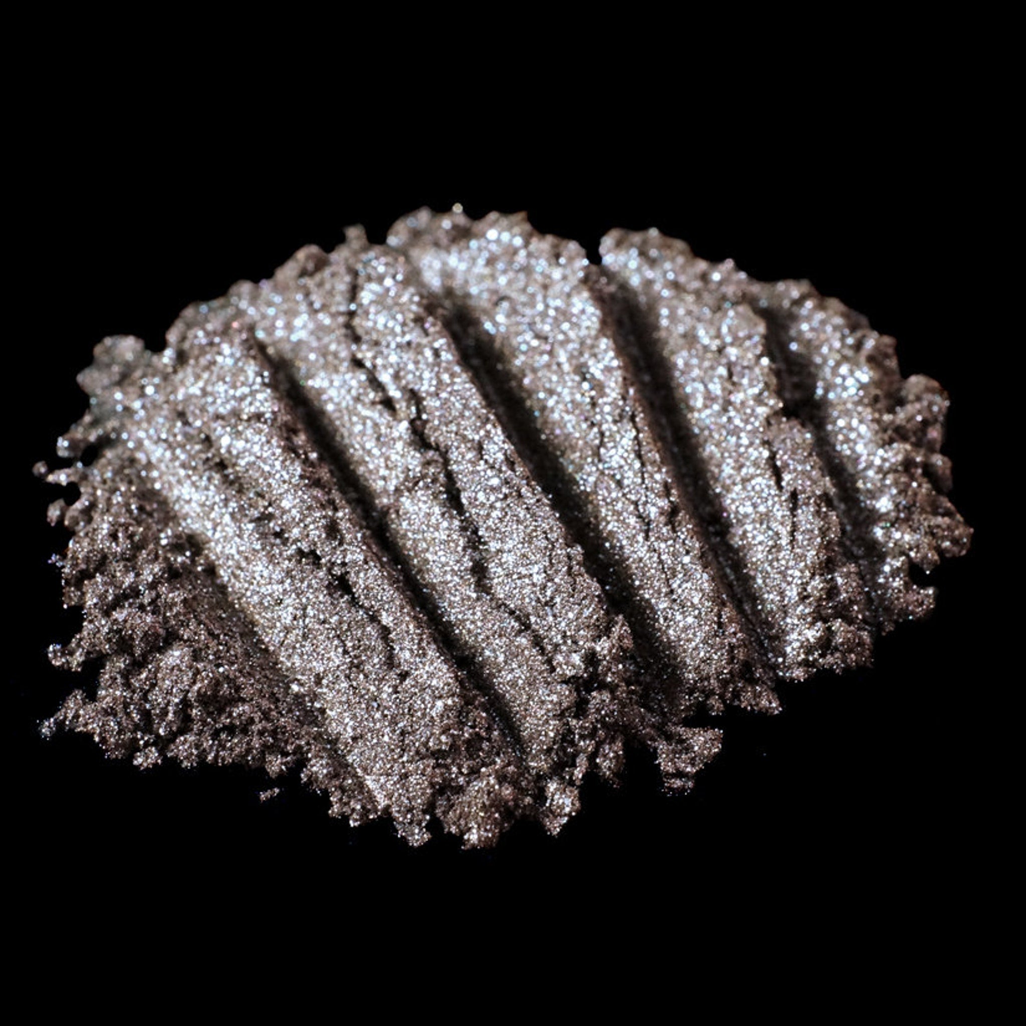 Metallic brown loose pigment eyeshadow with silver and blackened gold glitter in a sleek jar