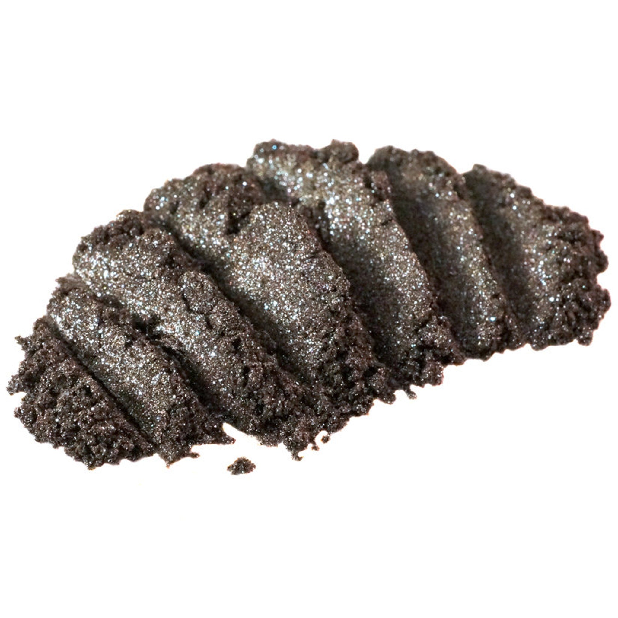 Close-up of loose bronze eyeshadow with silver and blackened gold glitter particles shimmering in light