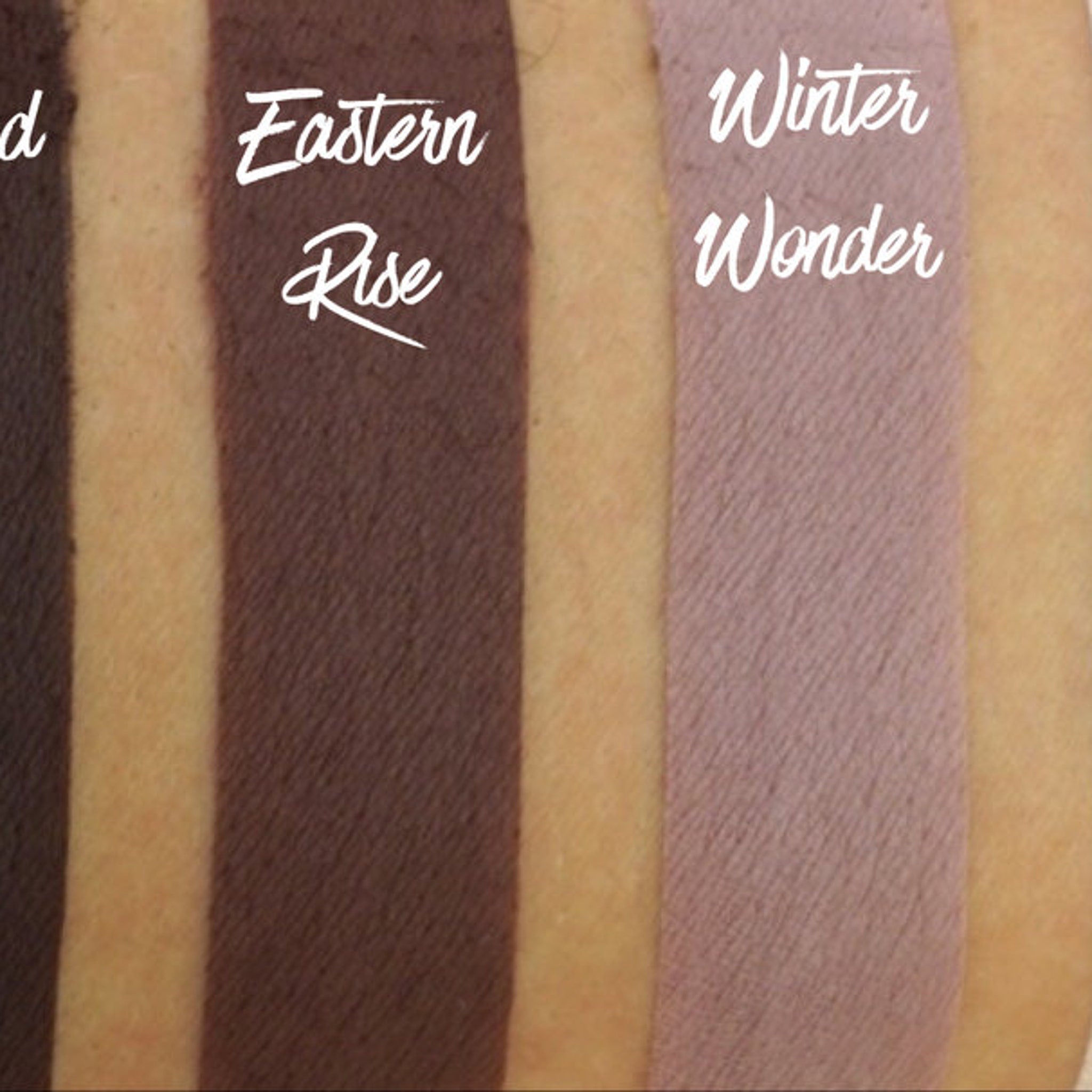 Eastern Rise matte eyeshadow pan in sleek black compact with silver logo, shown open on white background