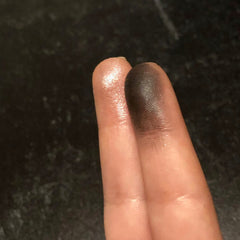Side view of Waxing Crescent Moon eyeshadow pan showing metallic silver shimmer and crescent-shaped imprint