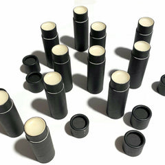 Lip balm tubes, black cardboard, white lip butter, scattered arrangement