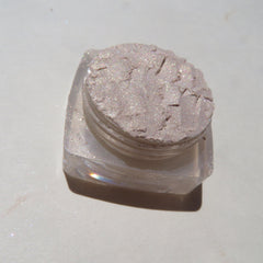 Close-up of loose mineral eyeshadow in pale yellow shimmer with golden flecks, vegan and cruelty-free