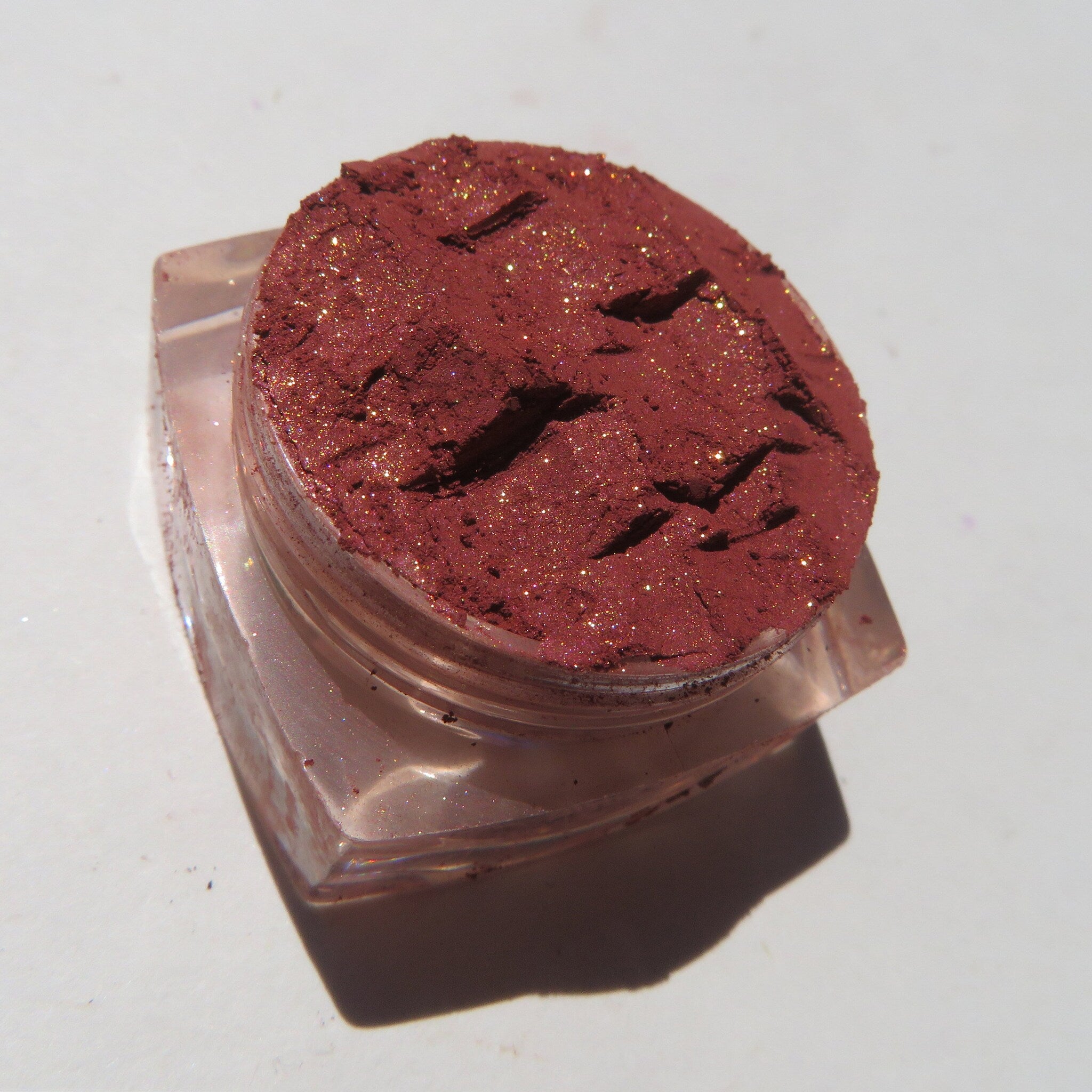 Open jar of brick red orange shimmer loose mineral eyeshadow with eco-friendly packaging and vegan label
