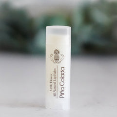 Lip balm tube, white plastic, brown text, Little Flower Piña Colada label