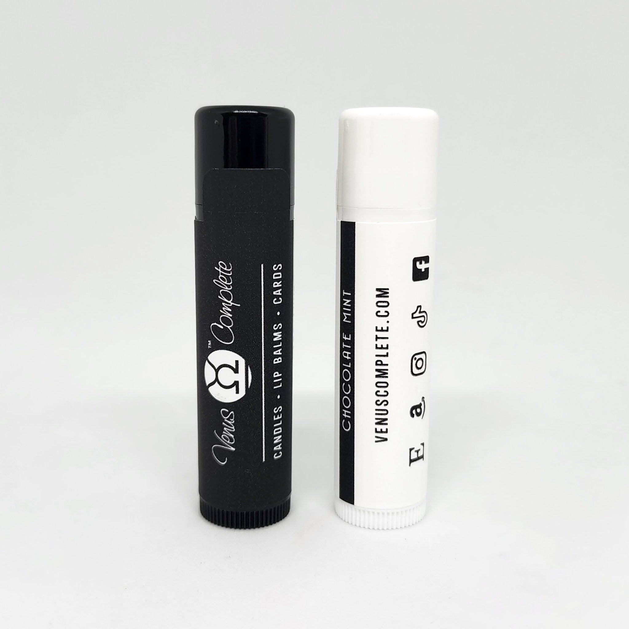 Lip balm tubes, black and white with Venus Complete branding and text labels